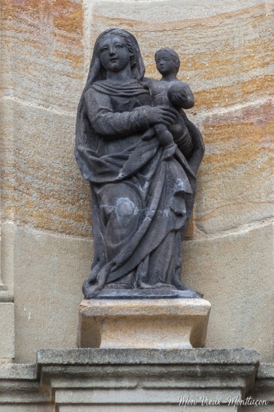 Église Notre-Dame, entrée ouest : Vierge à l'Enfant en pierre de Volvic, signée Bachelier datée de 1810. Cette statue était auparavant sur le couvercle de la fontaine de la place du même nom. Régulièrement vandalisée, elle est maintenant en sécurité. 0220_notre-dame_eglise_entree_statue-fontaine.jpg